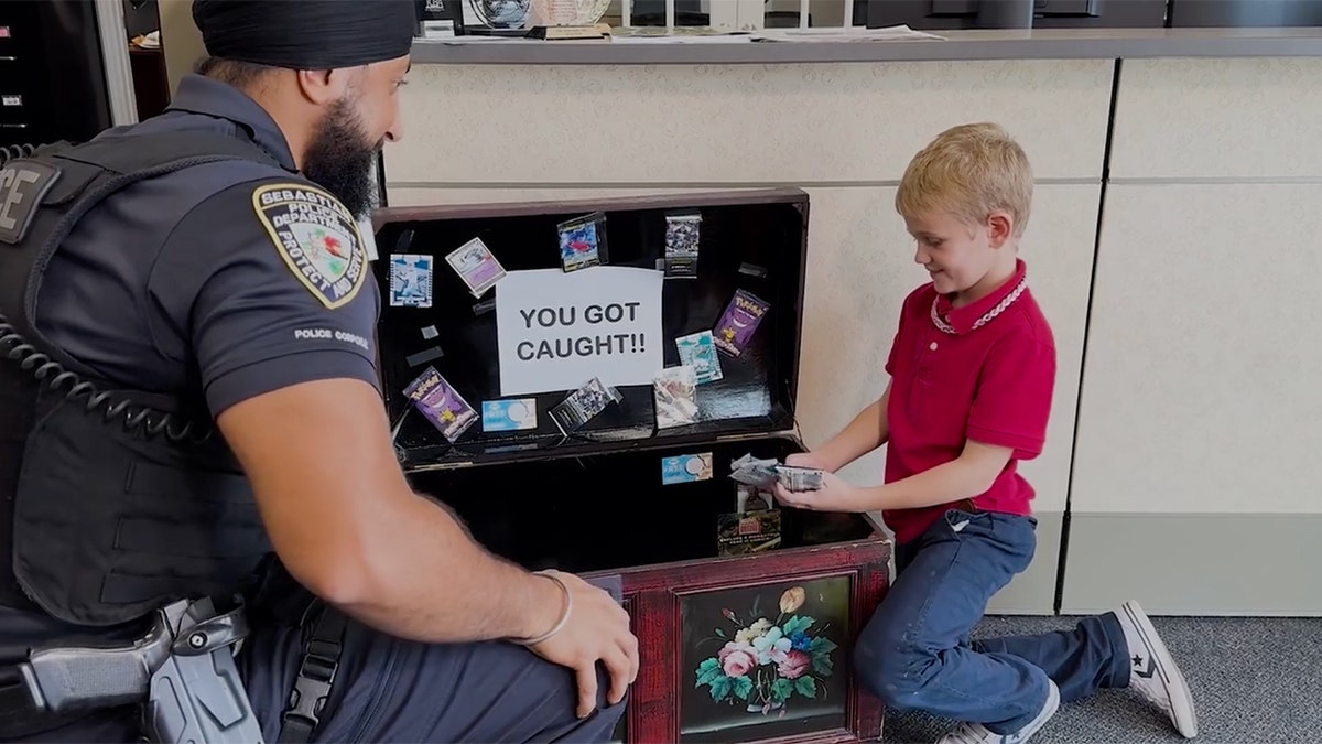 An officer and a child look through a treasure chest labeled "You got caught!"