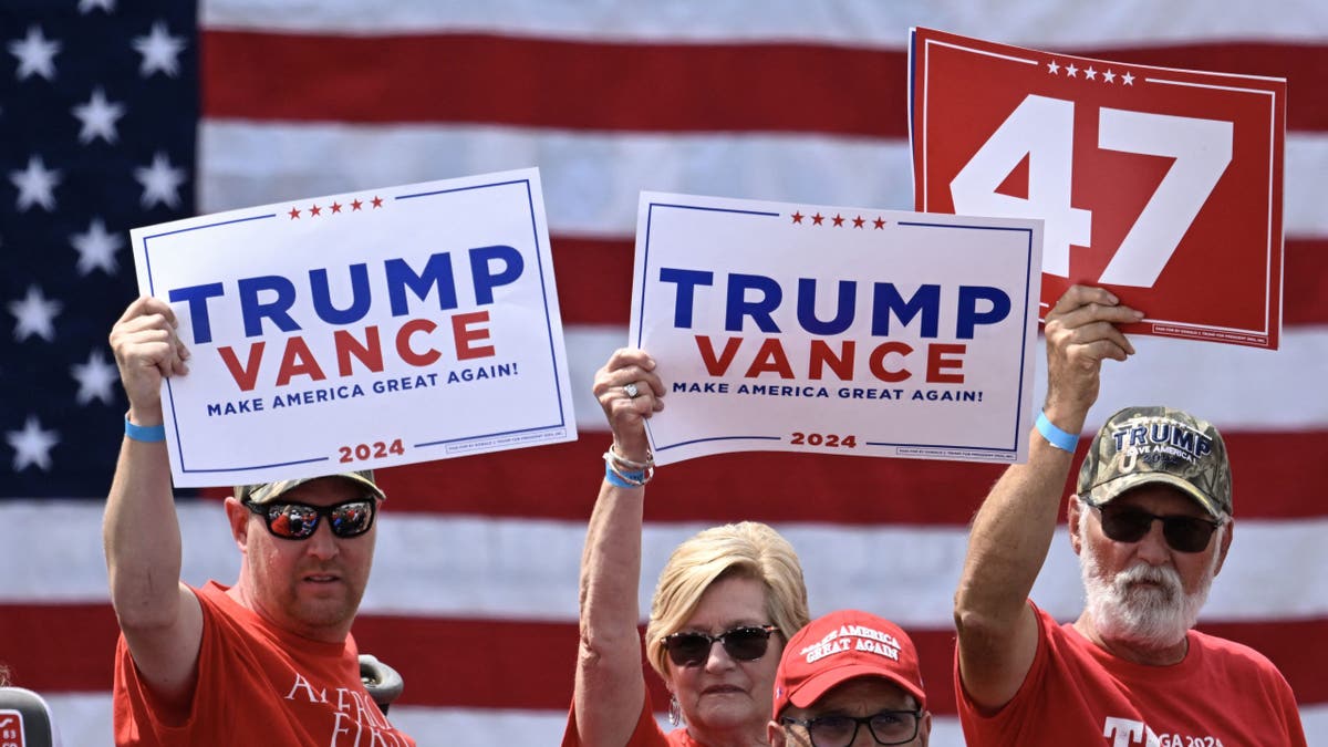 Trump supporters hold campaign signs