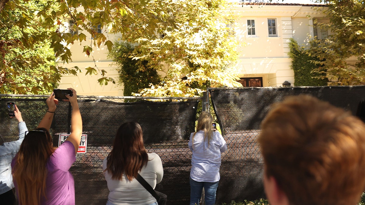 Visitors takes photos of the Menendez brothers' former mansion on Wednesday, Oct. 23, 2024 in Beverly Hills, CA.