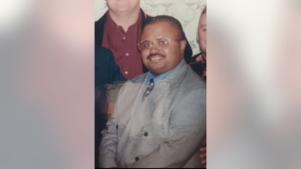 Michael Beverly in a grey suit and a blue shirt.