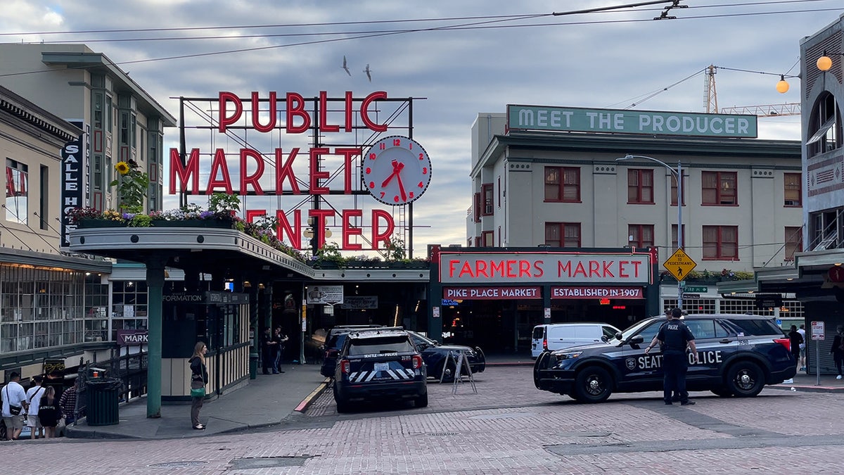 Seattle police officers stand near Pike Place Market on Tuesday, July 11, 2023.