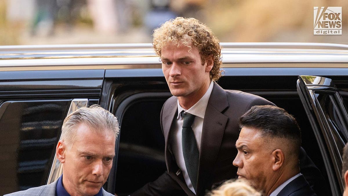 Daniel Penny dressed in a suit exits a large SUV as he arrives at court for his trial in the chokehold death of subway rider, Jordan Neely.