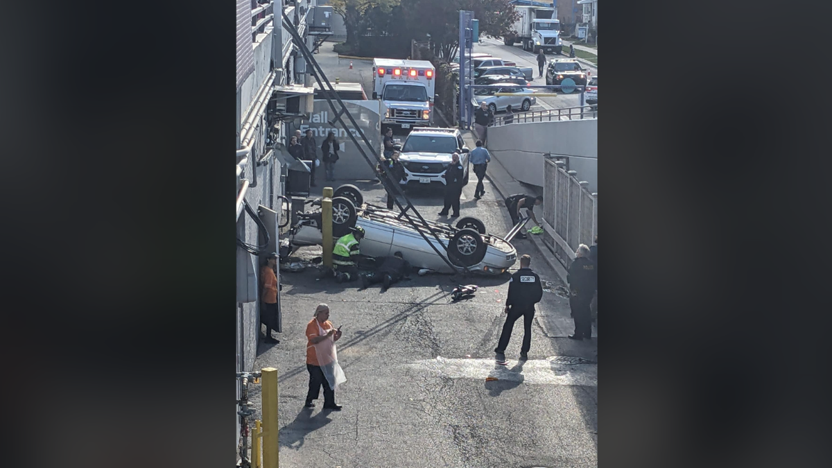 Authorities working near upside-down car