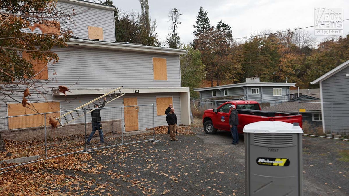 Investigators replace the plywood over the doors and windows to the home where four University of Idaho students were slain in November last year