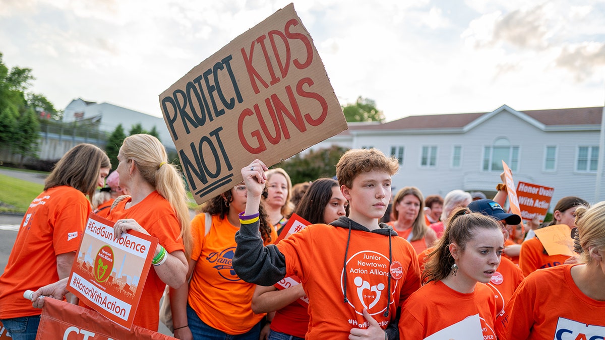 kid holds up sign at a gun violence awareness march