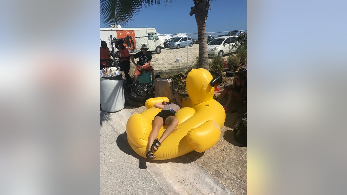 A woman rests on a giant blow-up duck at Fyre Festival in 2017.