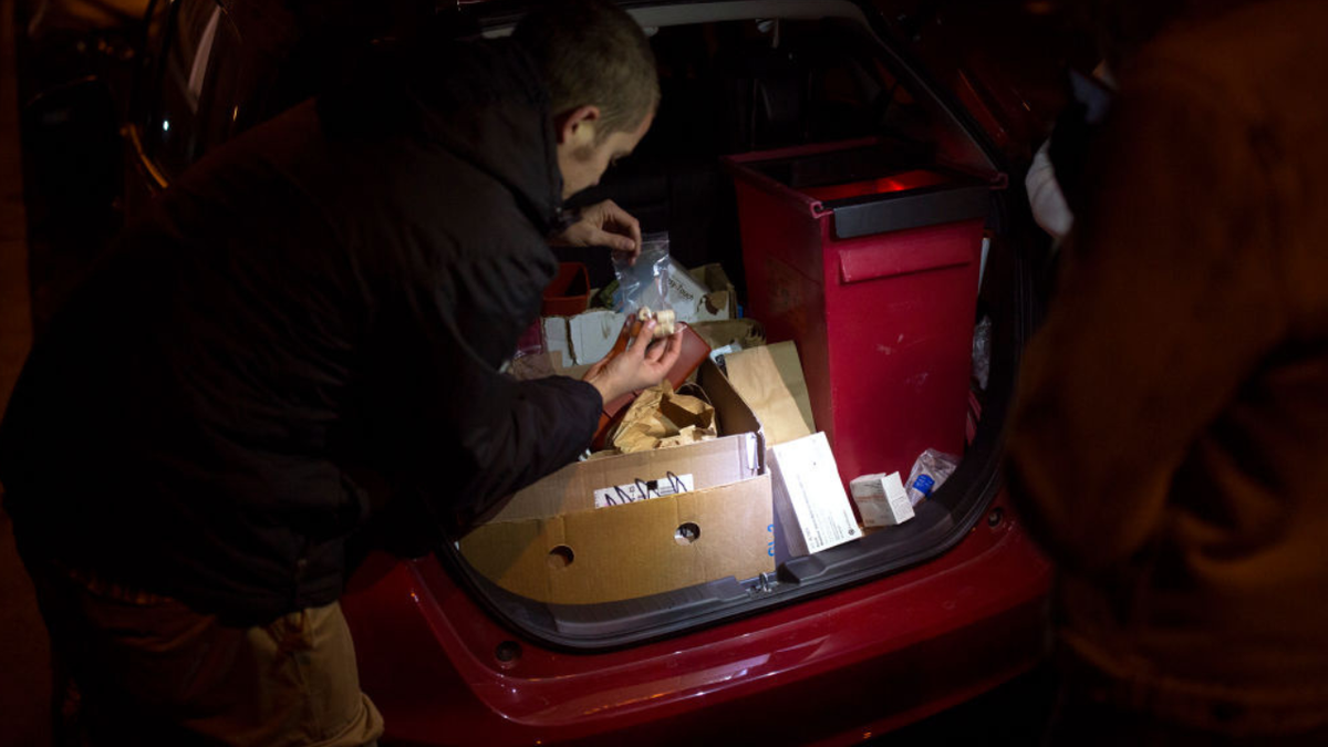 A man picking up a syringe on the streets of Maine.