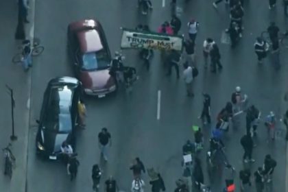 Car drives through anti-ICE protesters as Chicago joins nationwide anti-ICE unrest amid Trump crackdown
