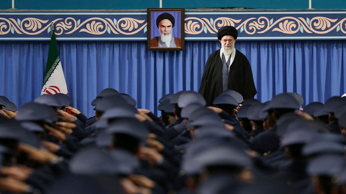 In this picture released by official website of the office of the Iranian supreme leader, Supreme Leader Ayatollah Ali Khamenei stands as army air force and air defense staff salute at the start of their meeting in Tehran, Iran, Thursday, Feb. 8, 2018. A portrait of the late revolutionary founder Ayatollah Khomeini hangs in background. (Office of the Iranian Supreme Leader via AP)