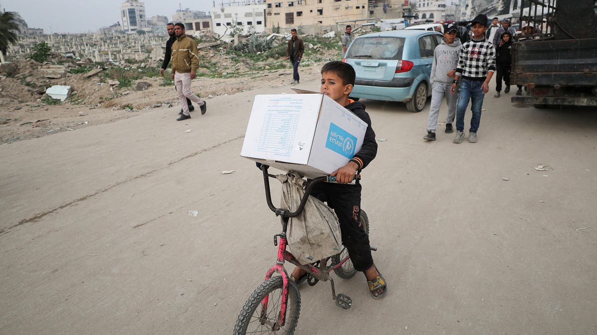 A Palestinian boy carries an aid box provided by UNRWA, amid a ceasefire between Hamas and Israel, in Gaza City, Feb. 3, 2025.