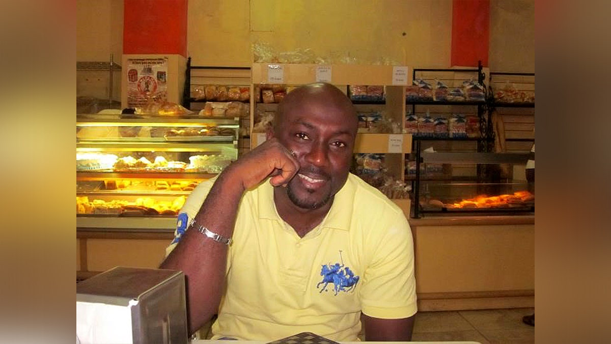 Aland Etienne wearing yellow shirt at bakery shop smiling