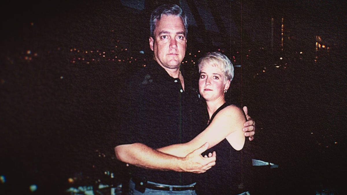 Amy Bradley wearing a black dress being held by her brother also wearing black.