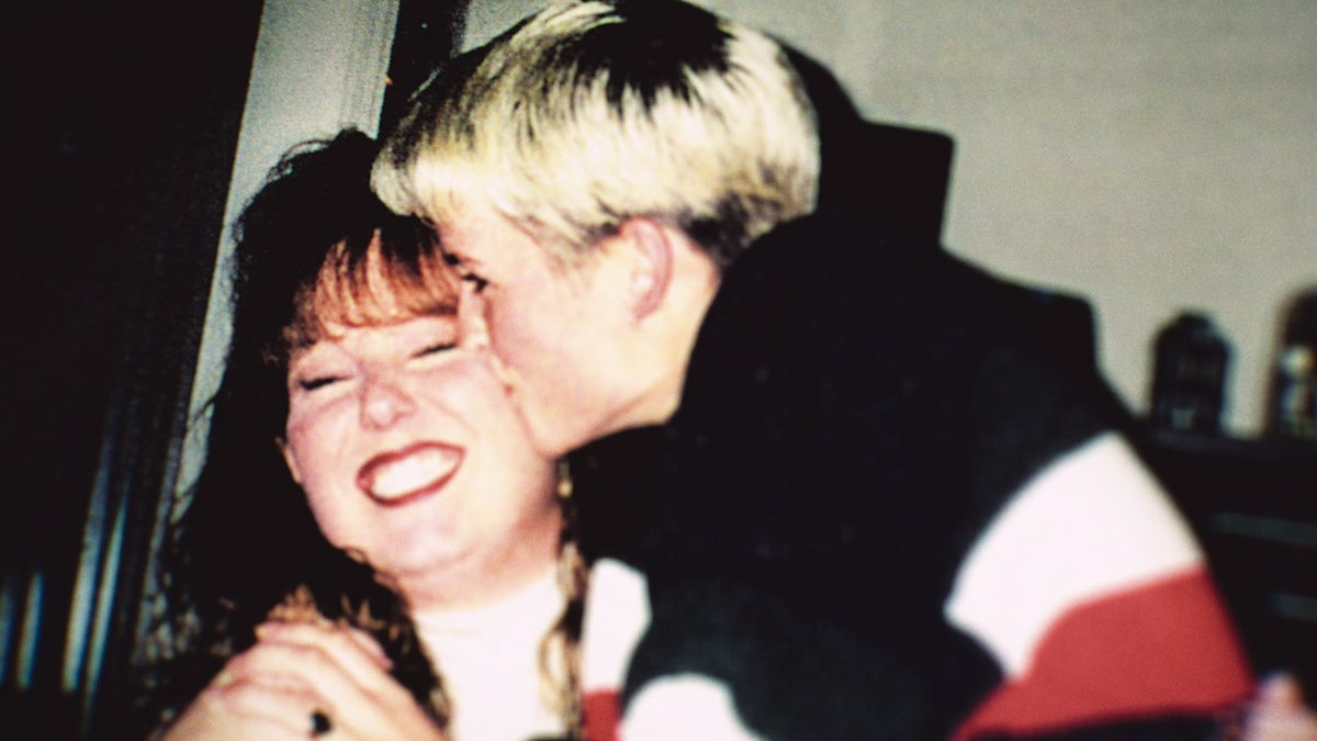 Amy Bradley kissing a smiling woman on the cheek.