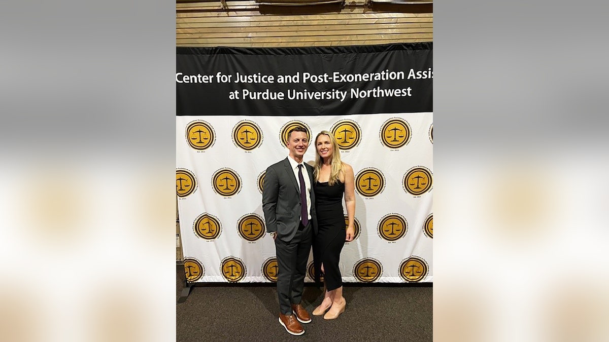 Denise Huskins and Aaron Quinn in formal wear standing at a step-and-repeat.