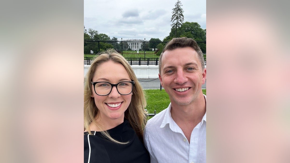 Denise Huskins and Aaron Quinn smiling in front of the White House