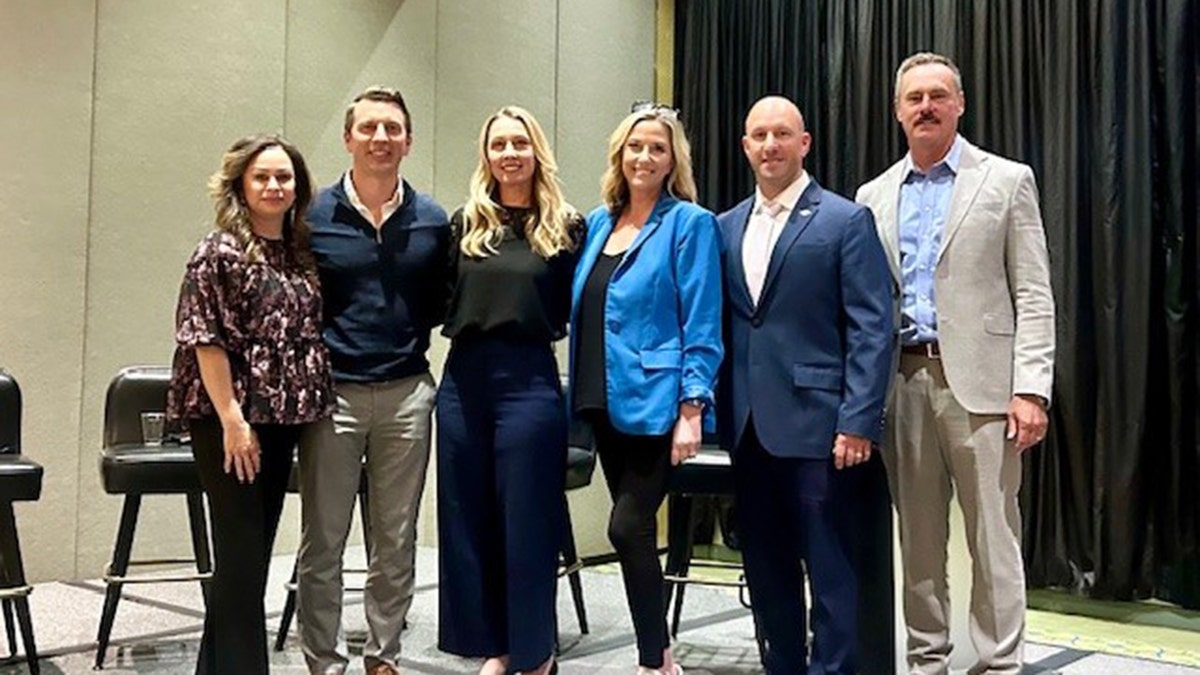 Denise Huskins and Aaron Quinn with a group of investigators posing for a photo.