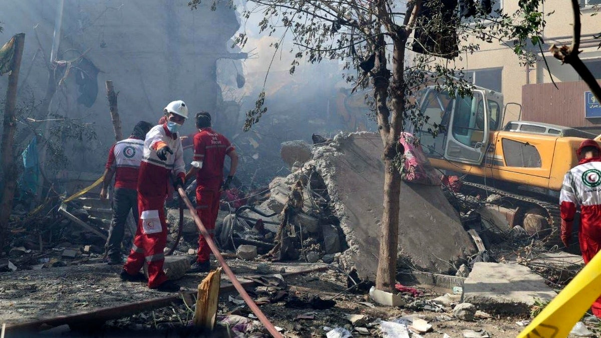 In this photo released by the Iranian Red Crescent Society rescuers work at the scene of an explosion after an Israeli strike in Tehran, Iran, Friday, June 13, 2025.