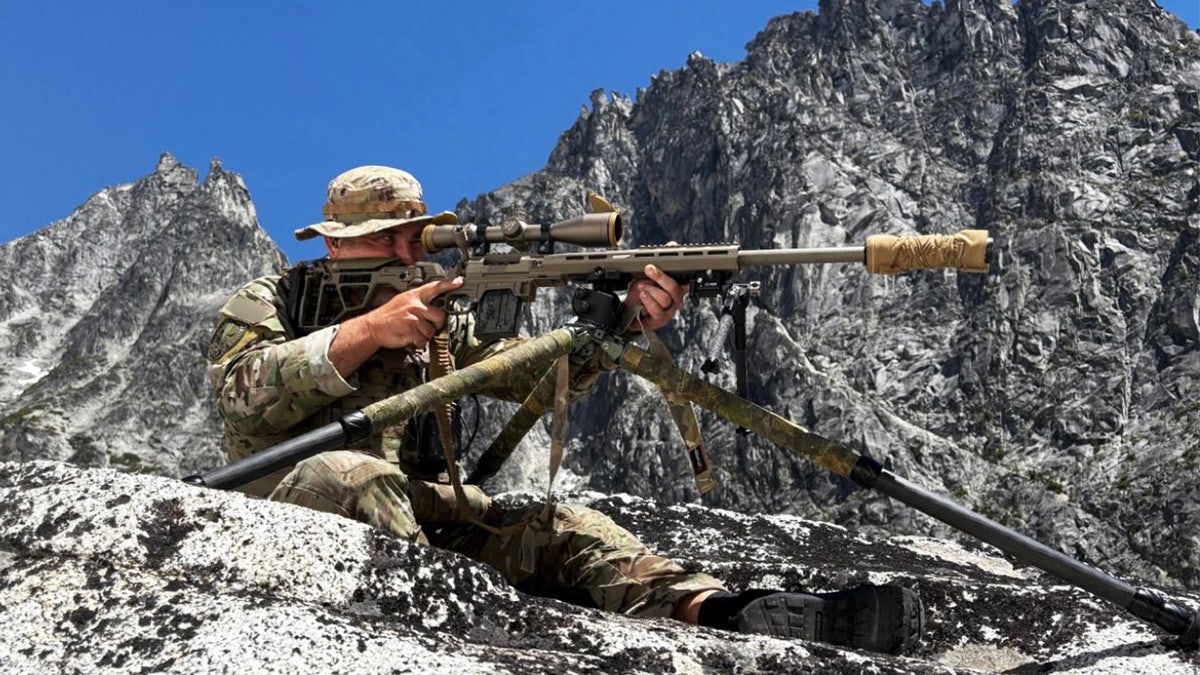 A U.S. Marshals member looks through a scope amid the search for Travis Decker