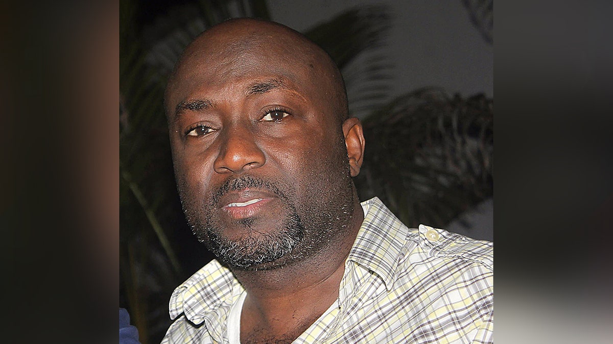 portrait of Aland Etienne wearing pale plaid shirt