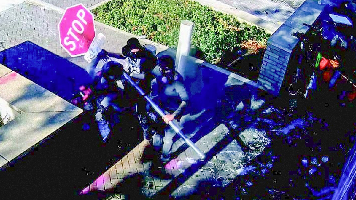 Suspect Robert Jacob Hoopes allegedly uses a stop sign as a battering ram