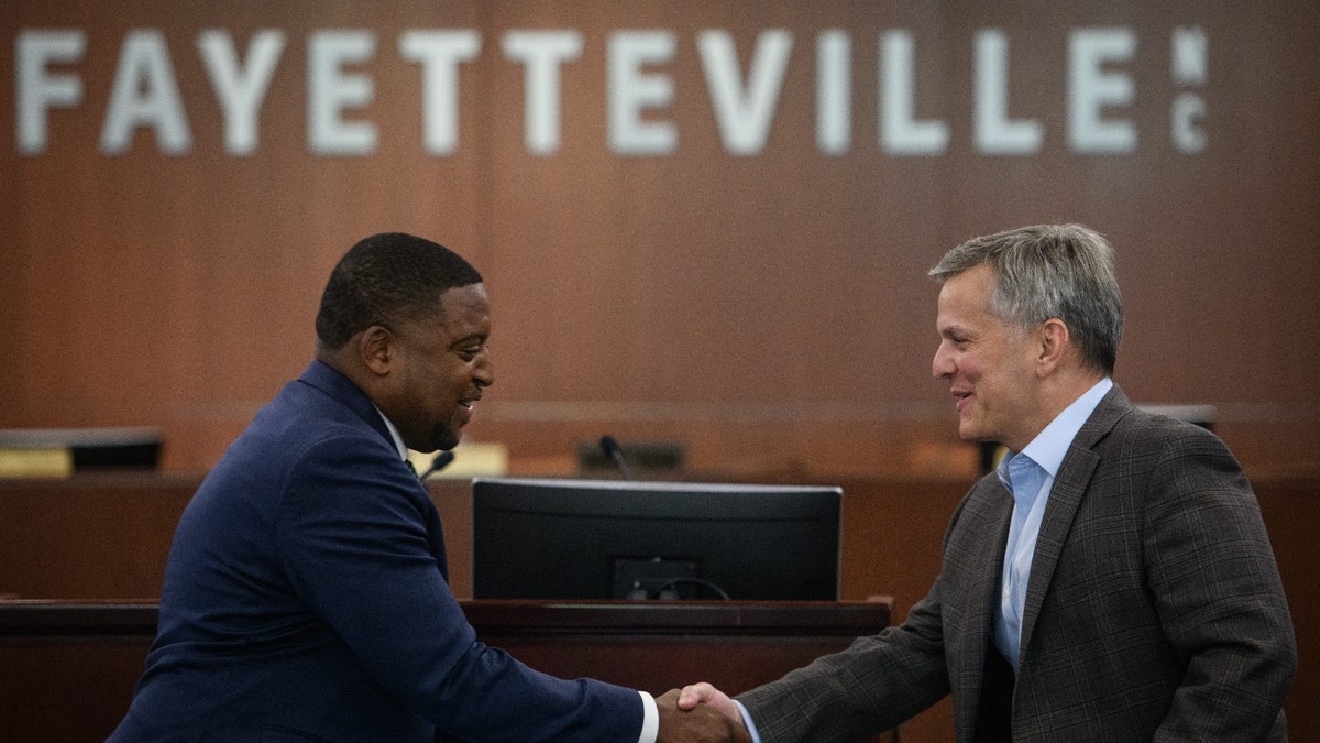 Fayetteville Mayor Mitch Colvin shakes then-North Carolina Attorney General Josh Stein's hand before a sign that reads, "Fayetteville, NC."