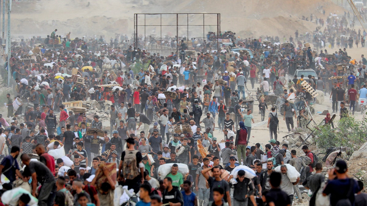 Palestinians carry aid from GHF