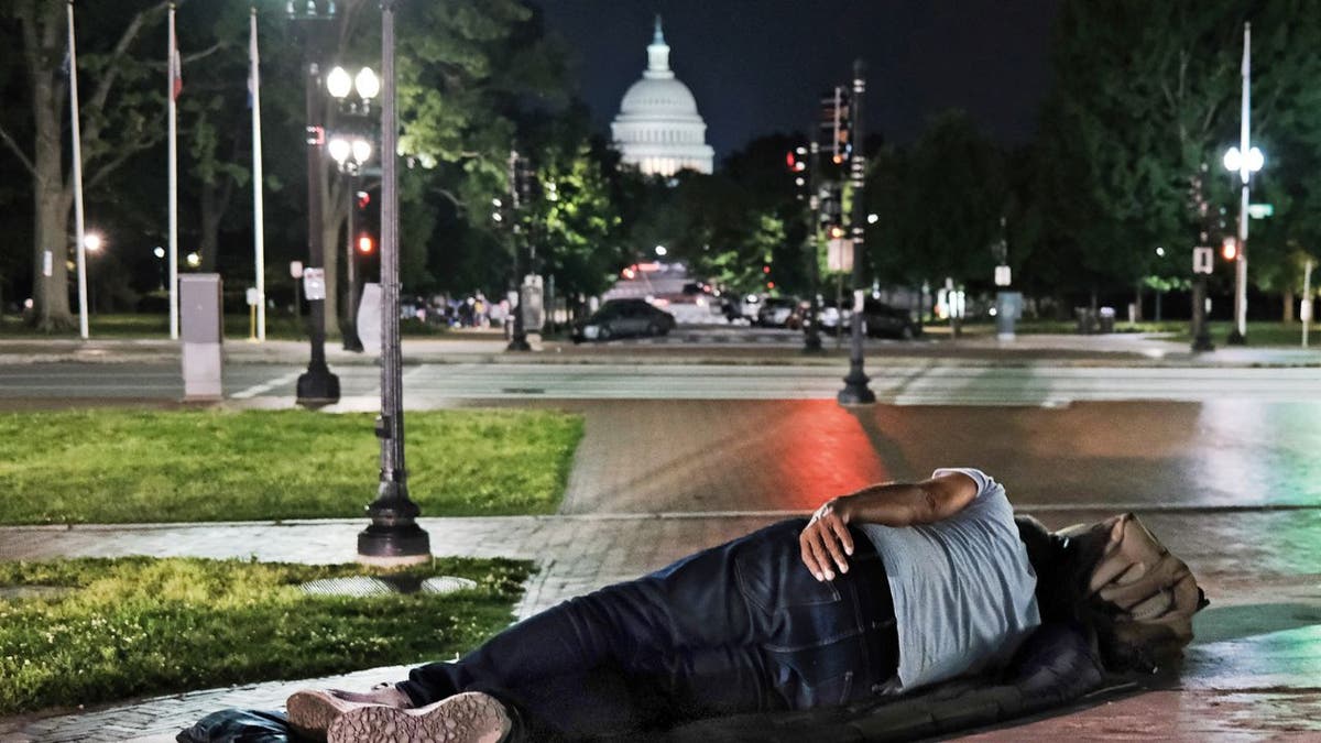 A man sleeps outside of the Union Station across from the US Capitol
