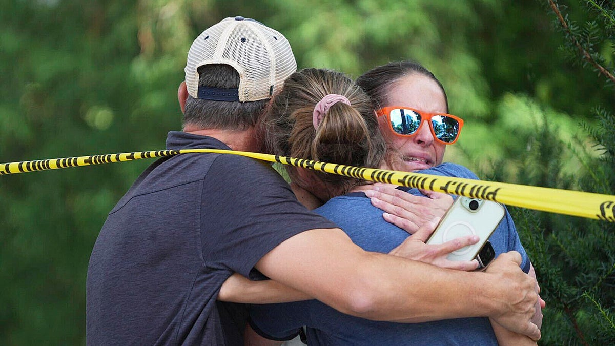 Community members embrace after Minnesota shooting