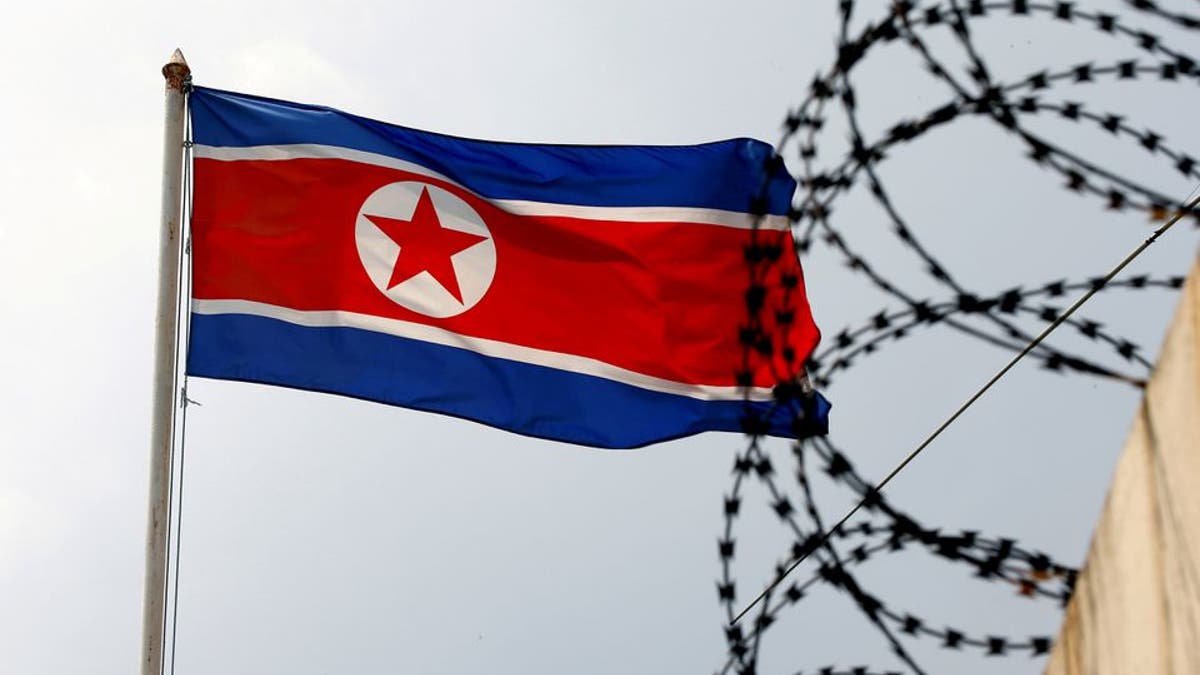 North Korea flag next to barb wire