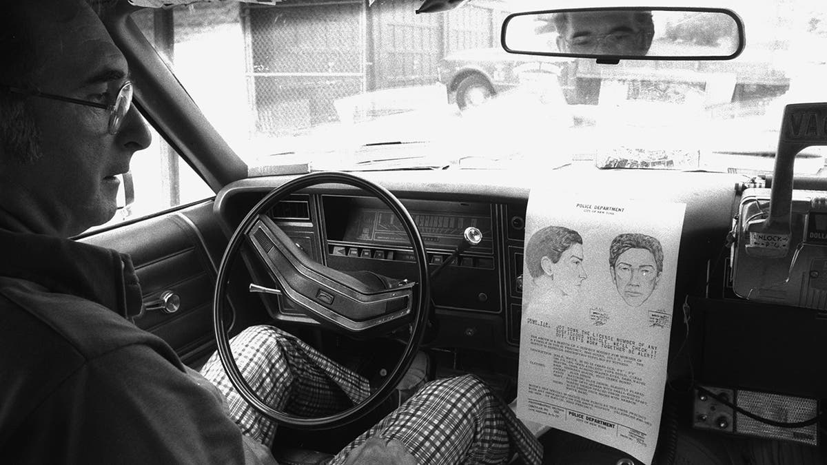 A cab driver looking at a wanted photo of David Berkowitz