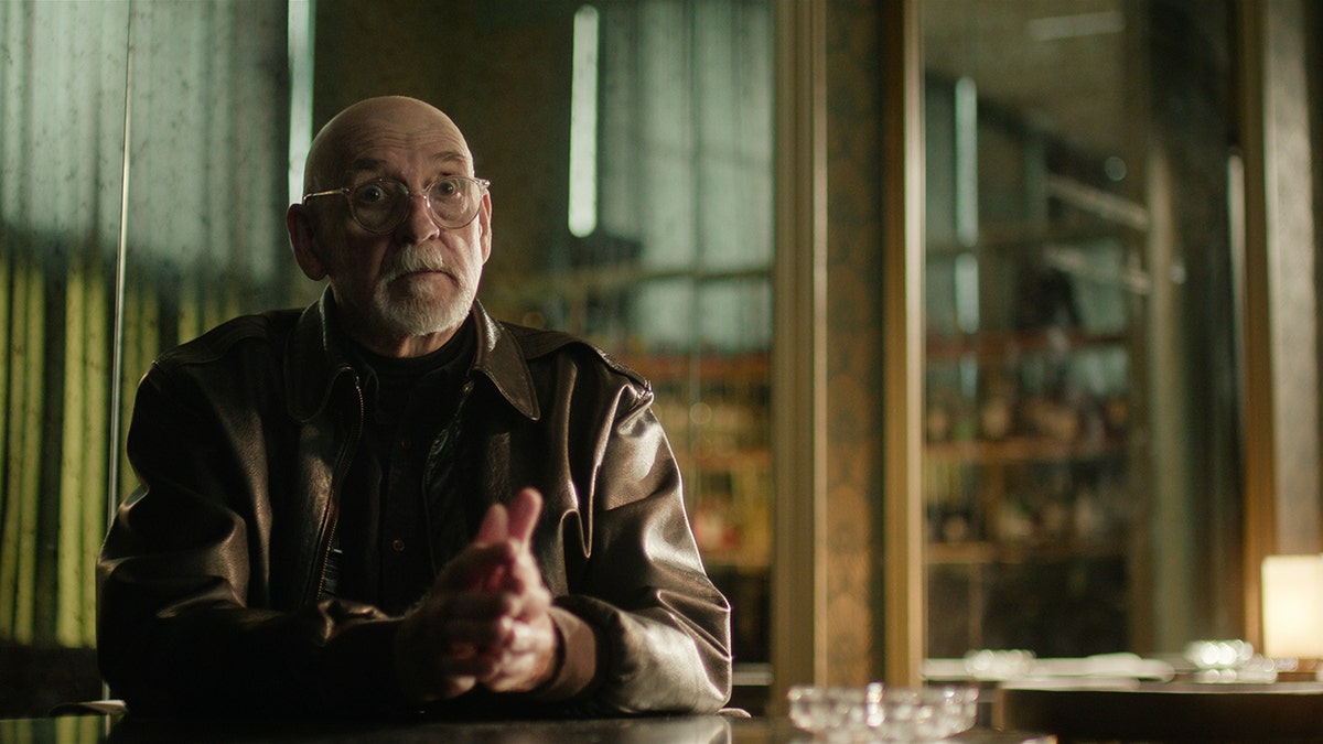 Jack Jones in a dark leather jack in mid-conversation.