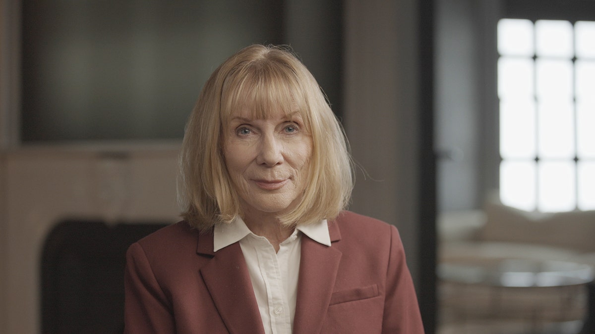 Dr. Katherine Ramsland wearing a coral blazer and white collared blouse.