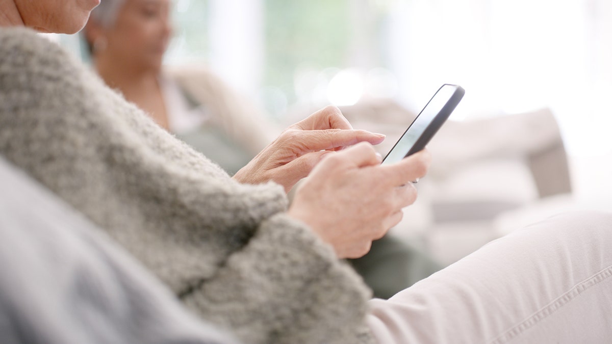 A senior citizen uses a smartphone
