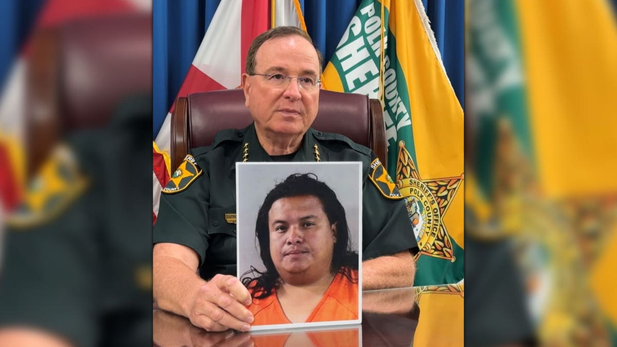 Polk County Sheriff Grady Judd holding Roberto Sandobal-Lopez mugshot
