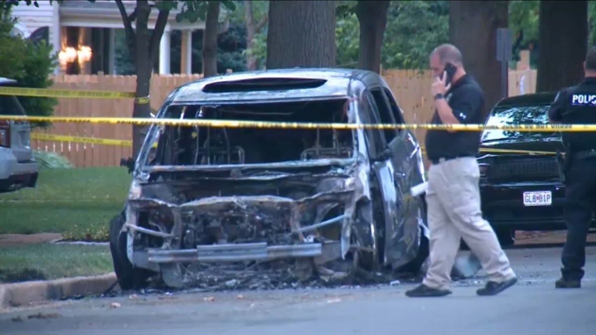 Car burned on street with police taped around