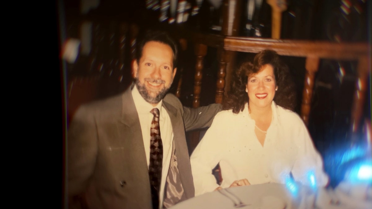 Larry Rudolph in a grey suit smiling with Bianca Rudolph wearing a white blouse.