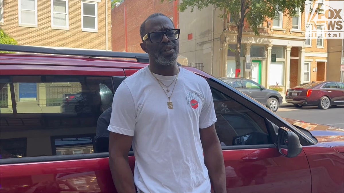 Corey Mitchell cincinnati white t-shirt leaning on a red car