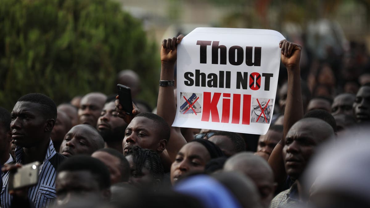 Christian faithful hold signs as they march on the streets of Abuja during a prayer and penance for peace and security in Nigeria in Abuja on March 1, 2020.