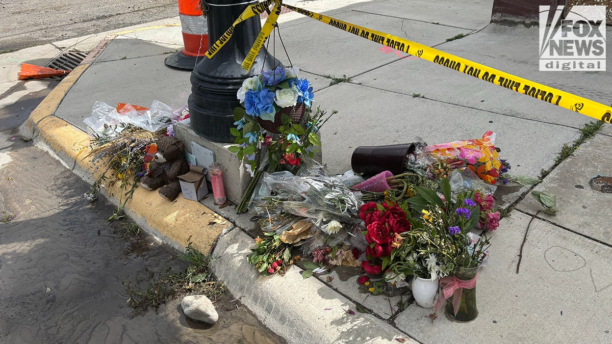 Flowers piled on street in front of The Owl Bar