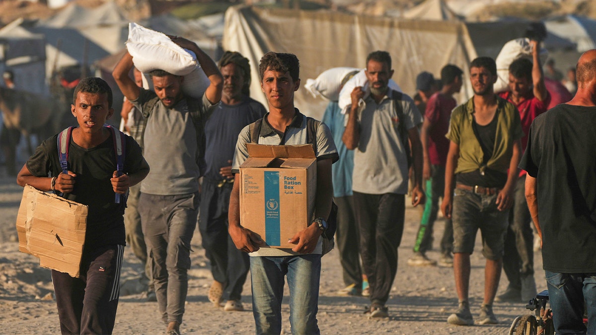 Palestinians carry boxes of aid