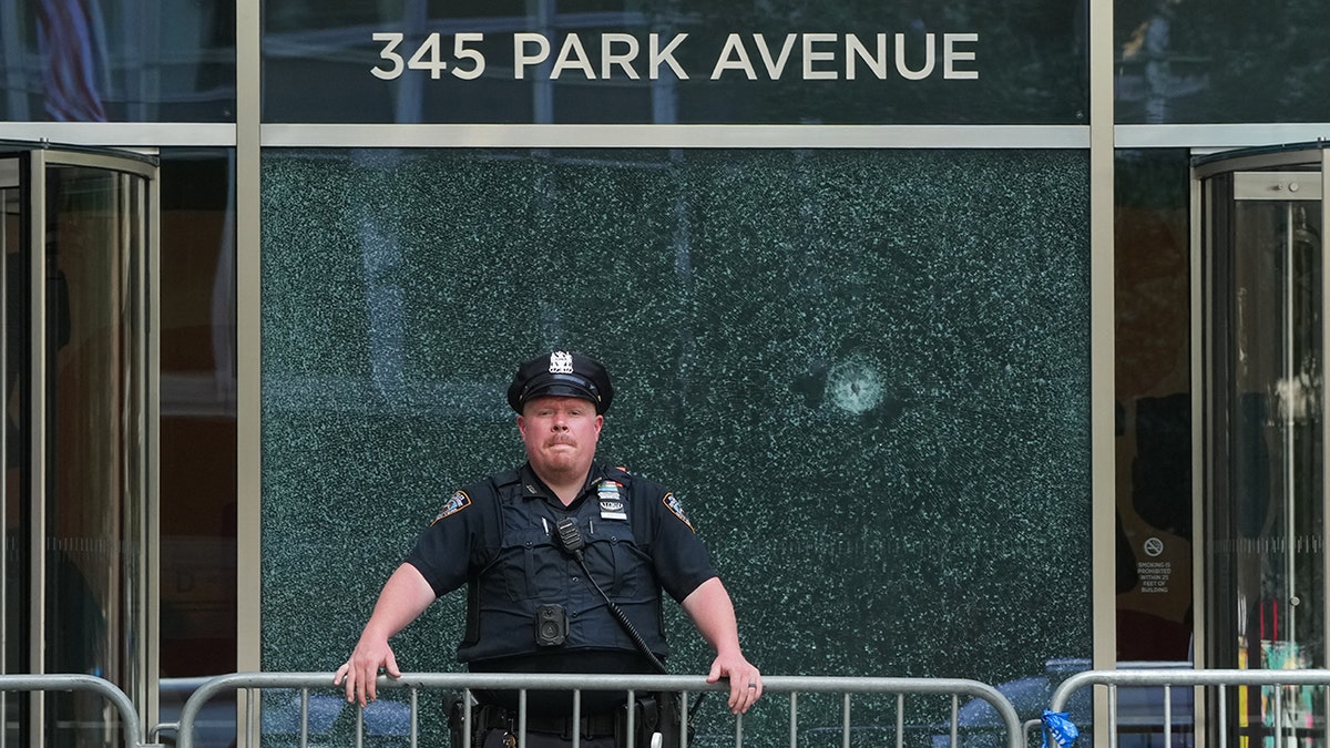 A New York City Police (NYPD) officer stands outside the 345 Park Avenue 