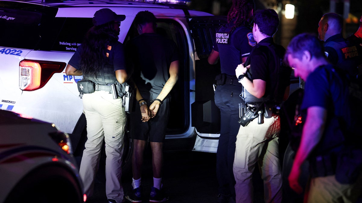 Police detains a person for driving without a license at Brightwood neighborhood after U.S. President Donald Trump's announcement of the federal take over of the Metropolitan Police Department under the Home Rule Act and the deployment of the National Guard to assist in crime prevention in the nation's capital, in Washington, D.C.