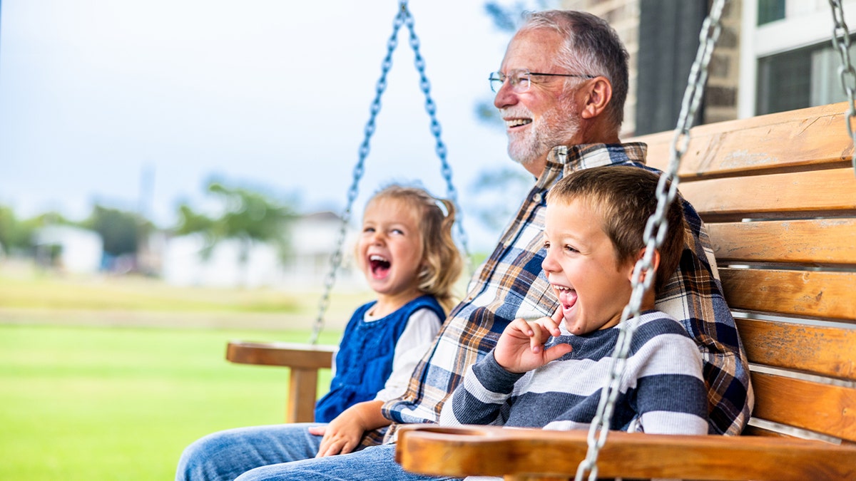 Grandpa on swing with kids