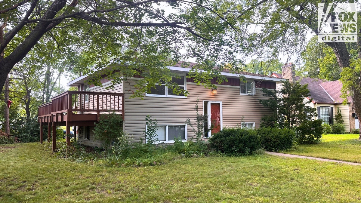 Exterior of a two-story split-level house with beige siding and red deck in St. Louis Park, where Robin Westman was believed to have stayed.