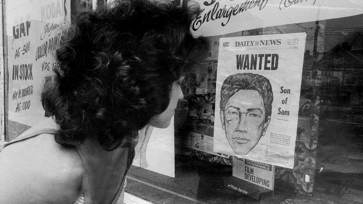 A woman looking at a wanted poster of David Berkowitz