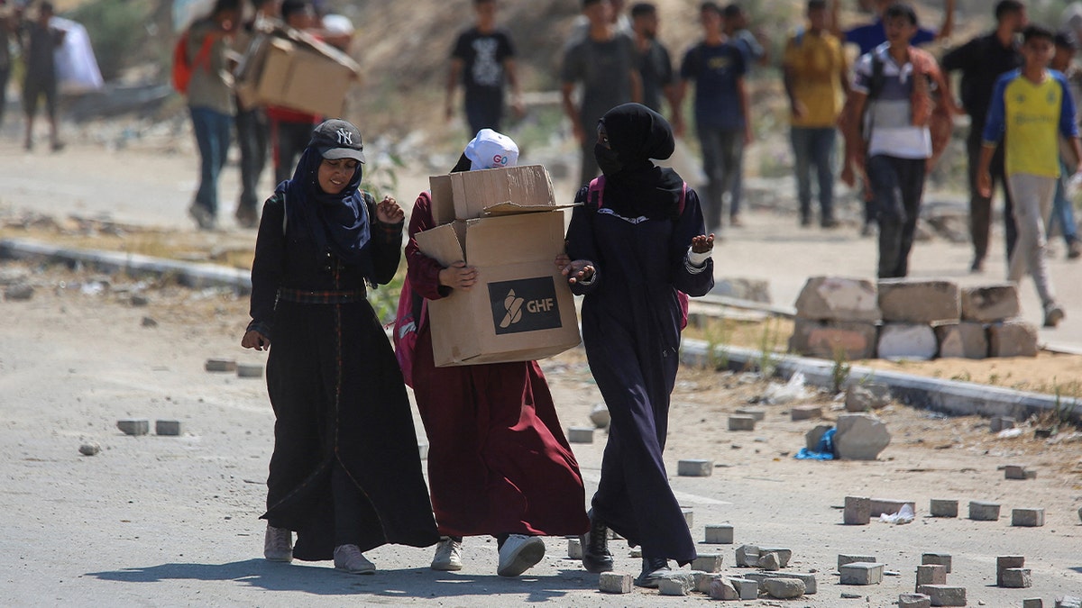 Palestinian women carrying aid