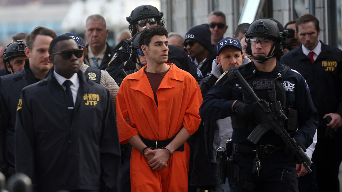 Luigi Mangione, suspect in the killing of UnitedHealthcare CEO Brian Thompson in New York City, arrives at a heliport with members of the NYPD on December 19, 2024, in New York City.
