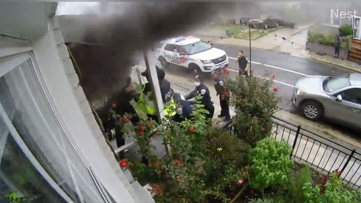 Security footage shows police officers attempting to open the front door of Benny Johnson’s rowhouse after the connected unit was set on fire. 