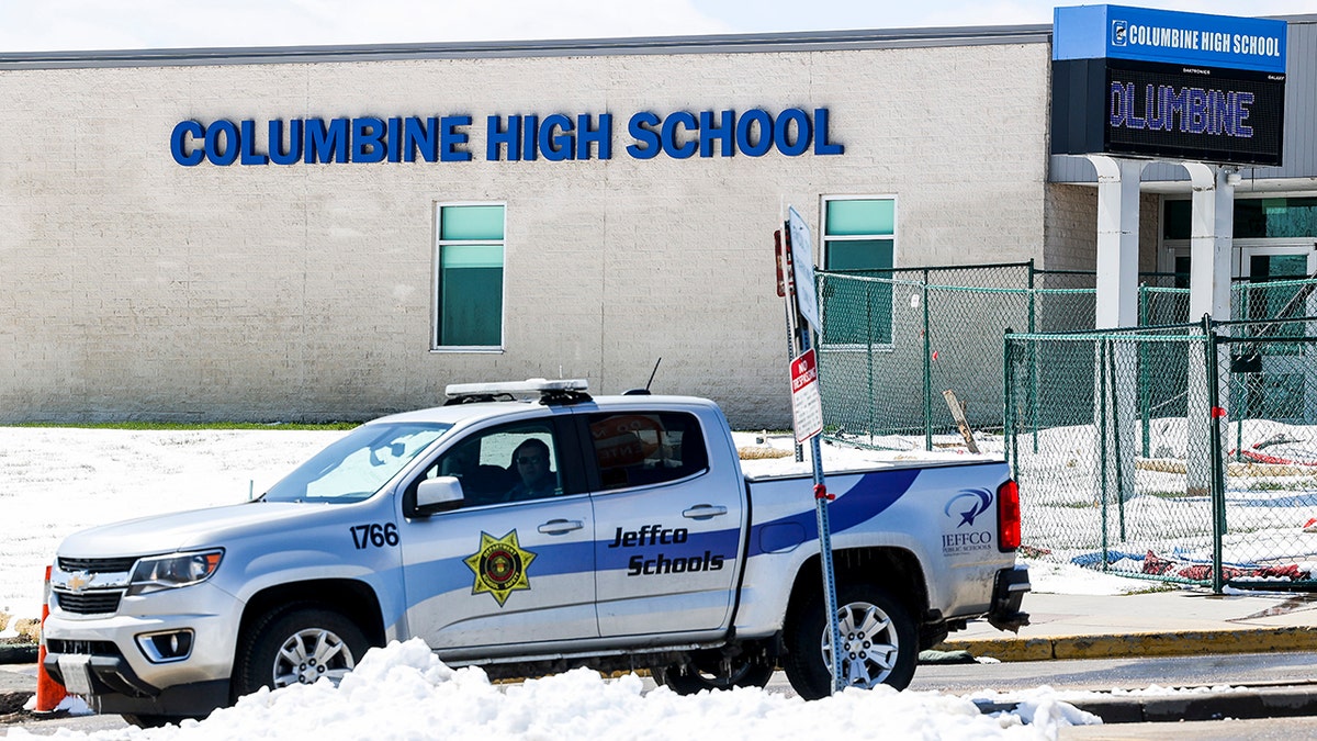 Police officers sit in the parking lot next to Columbine High School on April 20, 2021, in Littleton, Colo. Twelve students and a teacher were killed in the Columbine High School shooting, which at the time was the deadliest school shooting in U.S. history.