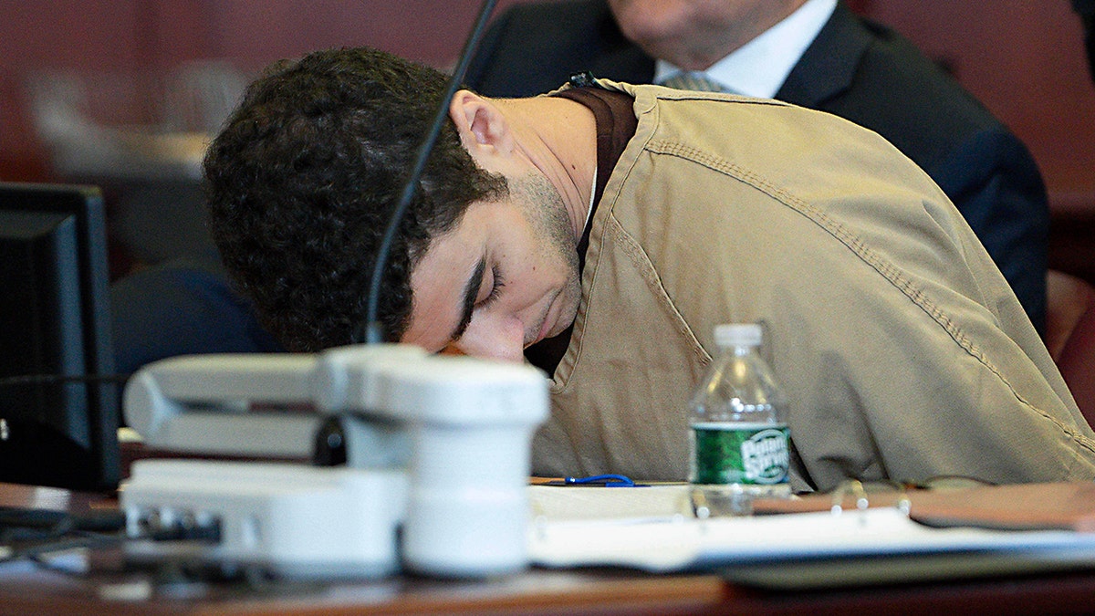 Luigi Mangione seated in court as judge drops terrorism charges.